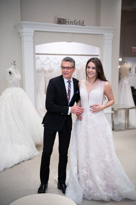 randy standing with the bride showing her the dress 
